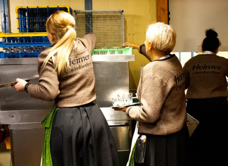 3 Kolleginnen in Heimer Tracht beim Geschirr einräumen.